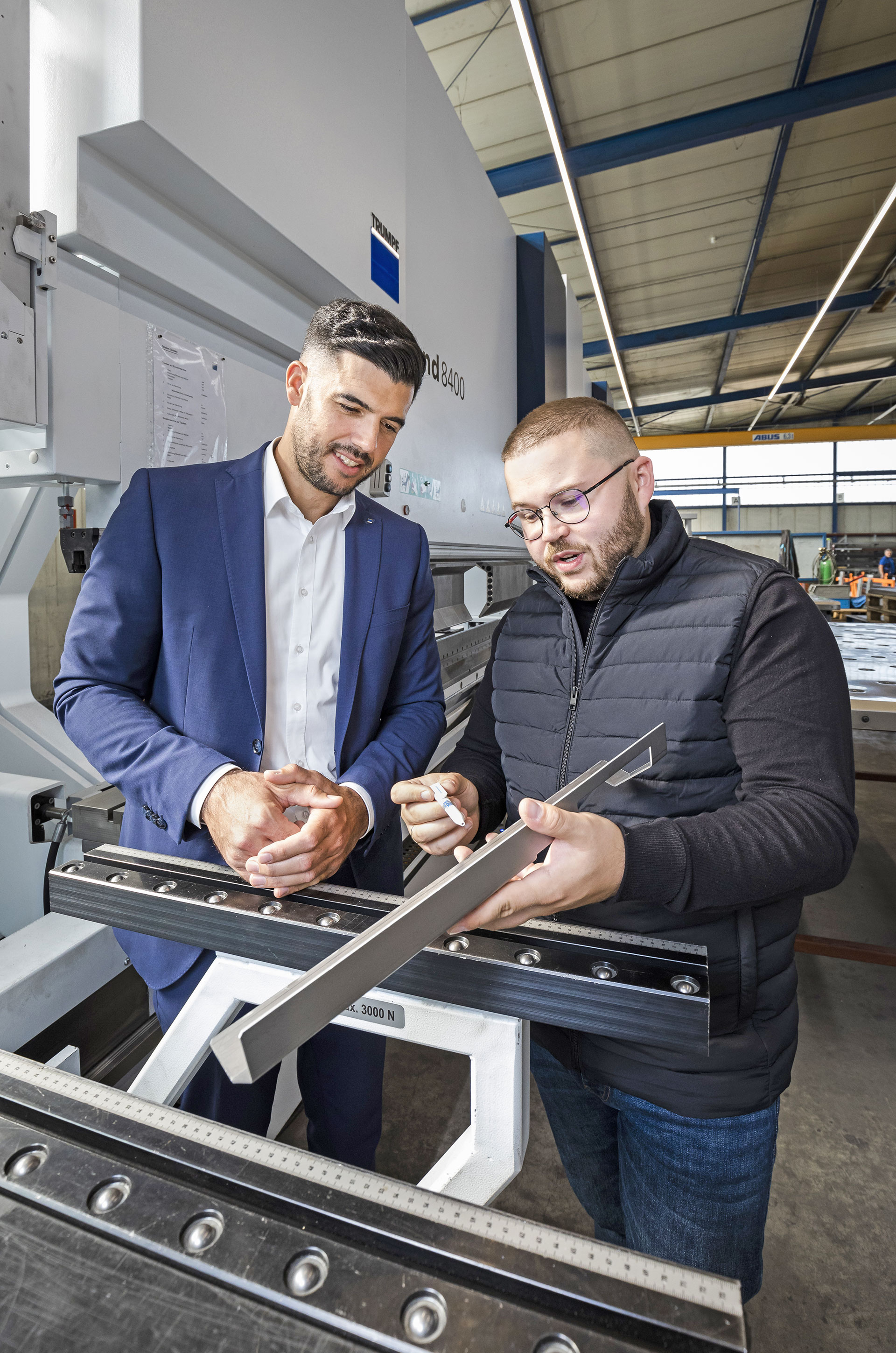 Trumpf-Außendienstmitarbeiter Felix Kuster besucht die Metalltechnikfirma HFK in Willstätt bei Offenburg.  Ein Mitarbeiter zeigt ihm etwas an einer Metalltechnikmaschine. 